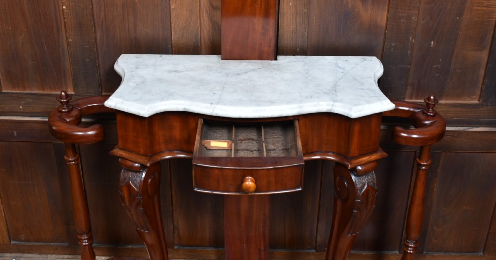 A Victorian mahogany hall stand featuring carved coat hooks, a central narrow mirror, a marble top over a single drawer, and integrated umbrella stands with drip trays. View IX