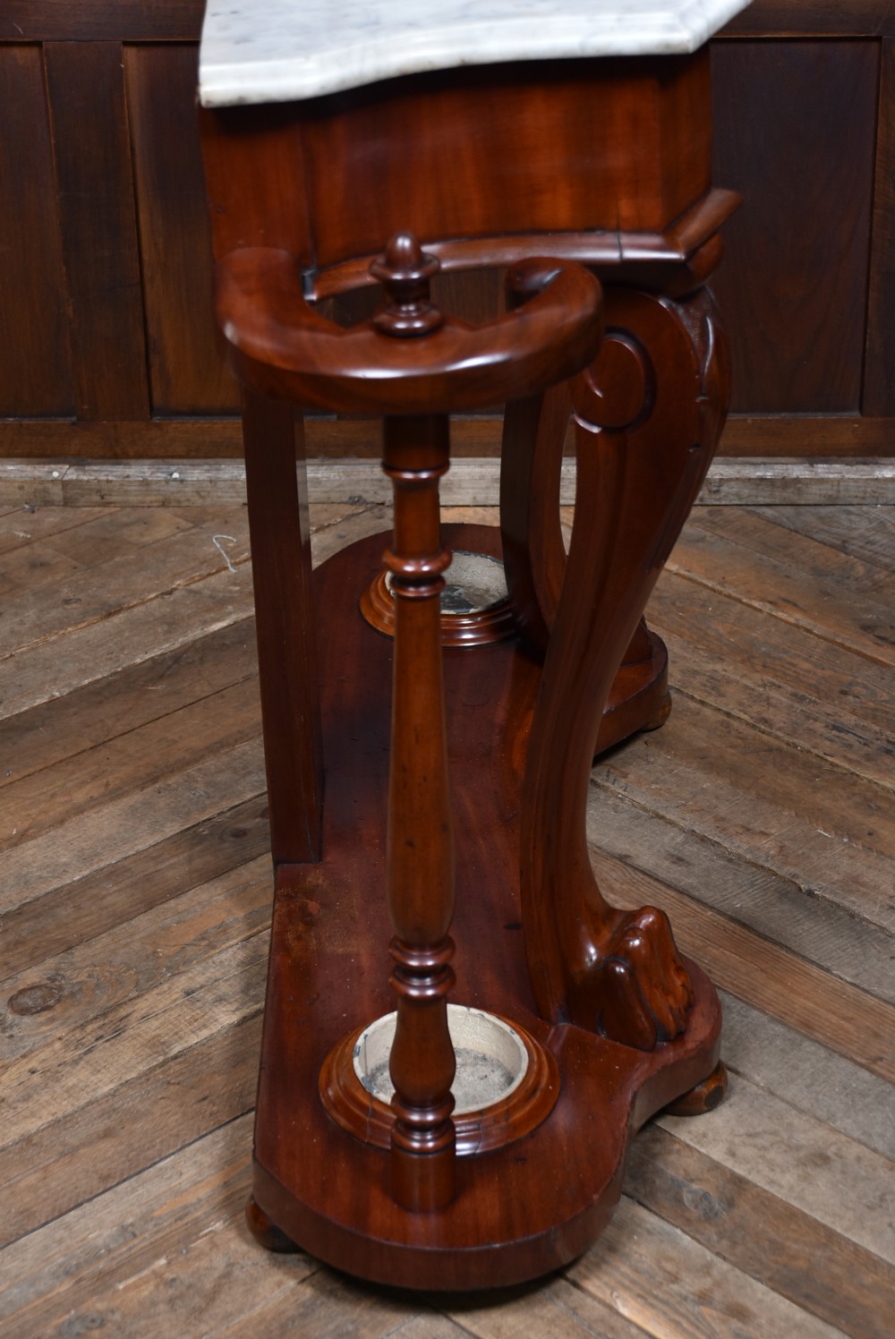 A Victorian mahogany hall stand featuring carved coat hooks, a central narrow mirror, a marble top over a single drawer, and integrated umbrella stands with drip trays. View XII