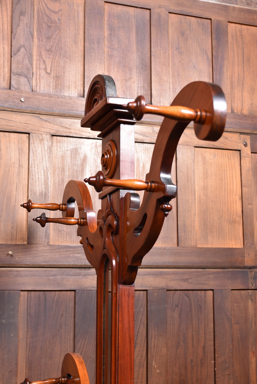 A Victorian mahogany hall stand featuring carved coat hooks, a central narrow mirror, a marble top over a single drawer, and integrated umbrella stands with drip trays. View XV