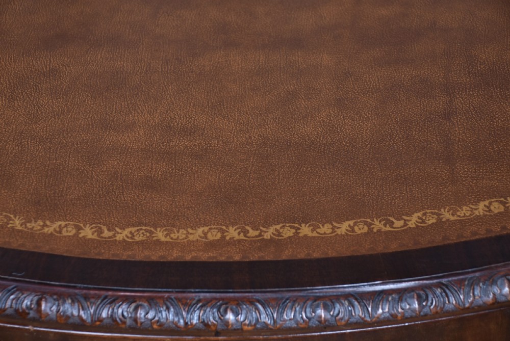 An Edwardian mahogany writing desk featuring a leather inset top, carved cabriole legs with ball-and-claw feet, and five drawers with brass swan-neck handles. View VIII