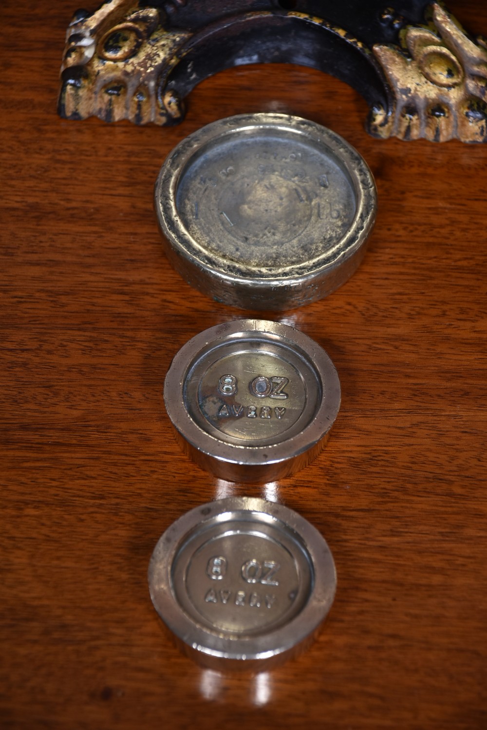 An Edwardian brass shopkeeper balance scale set on a central column base with two suspended pans and matching brass weights. View VIII