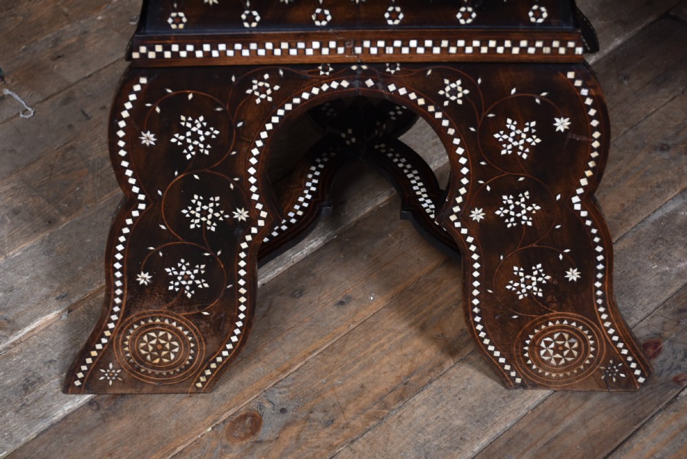 A pair of dark wood armchairs intricately decorated with white geometric bone inlay throughout the backrests, seats, arms, and legs. View XI