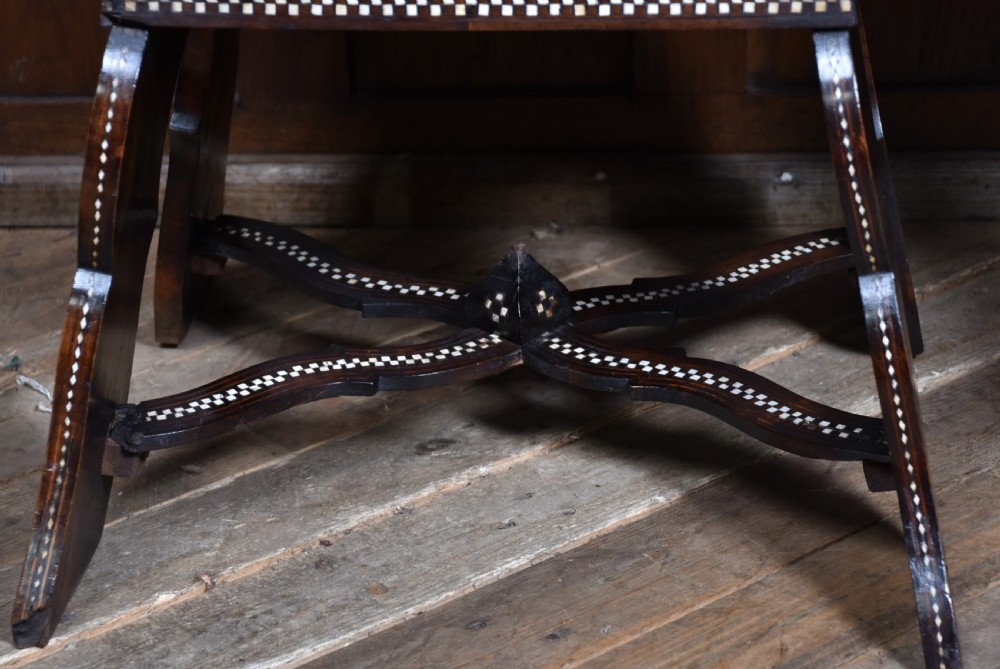 A pair of dark wood armchairs intricately decorated with white geometric bone inlay throughout the backrests, seats, arms, and legs. View XV