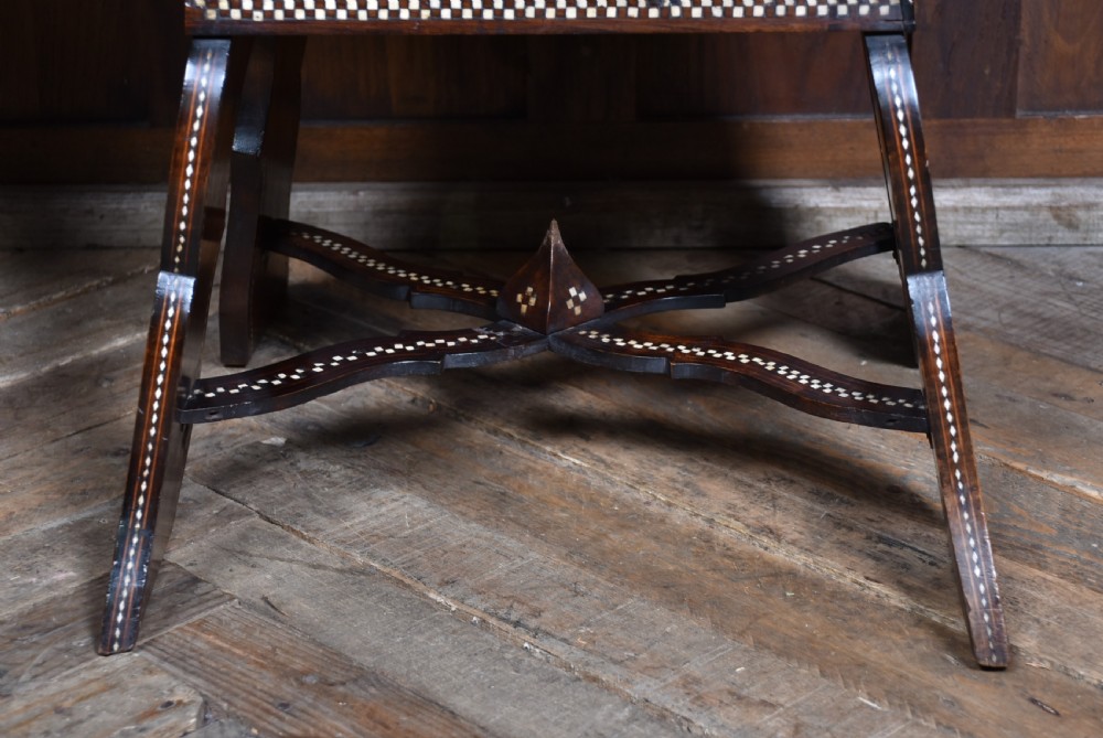 A pair of dark wood armchairs intricately decorated with white geometric bone inlay throughout the backrests, seats, arms, and legs. View XVI