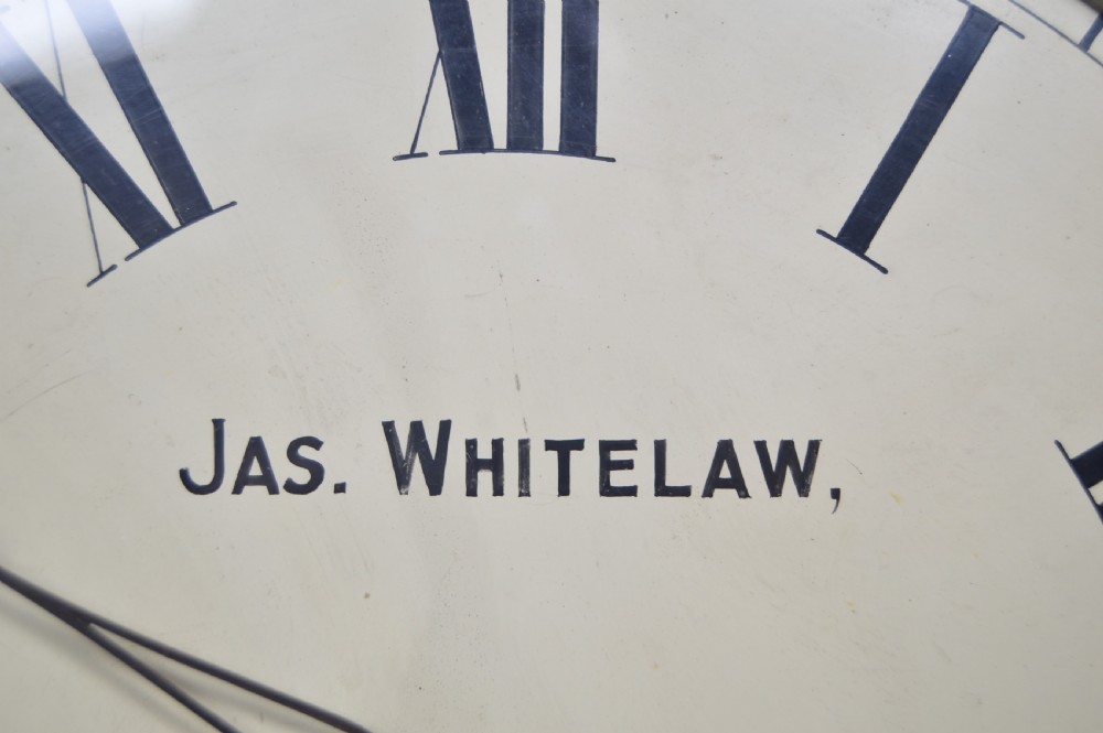 An Edwardian oak mantel clock featuring a curved wooden frame, a brass-rimmed glass face with Roman numerals, and the inscription Jas Whitelaw Edinburgh. View II