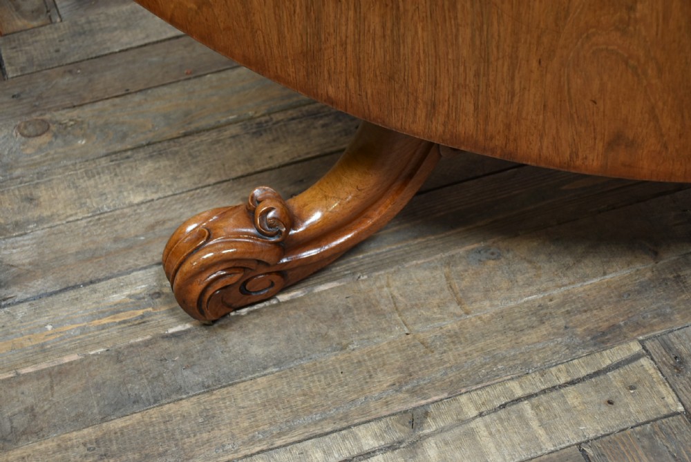 A Victorian rosewood snap-top supper table with a polished circular top tilted vertically on a carved tripod base. View III