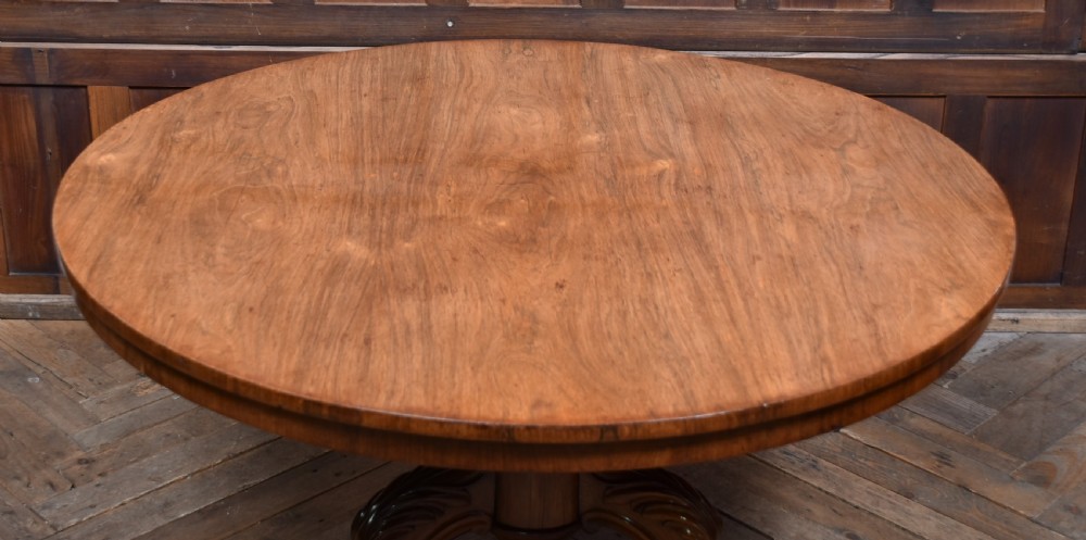 A Victorian rosewood snap-top supper table with a polished circular top tilted vertically on a carved tripod base. View XIII