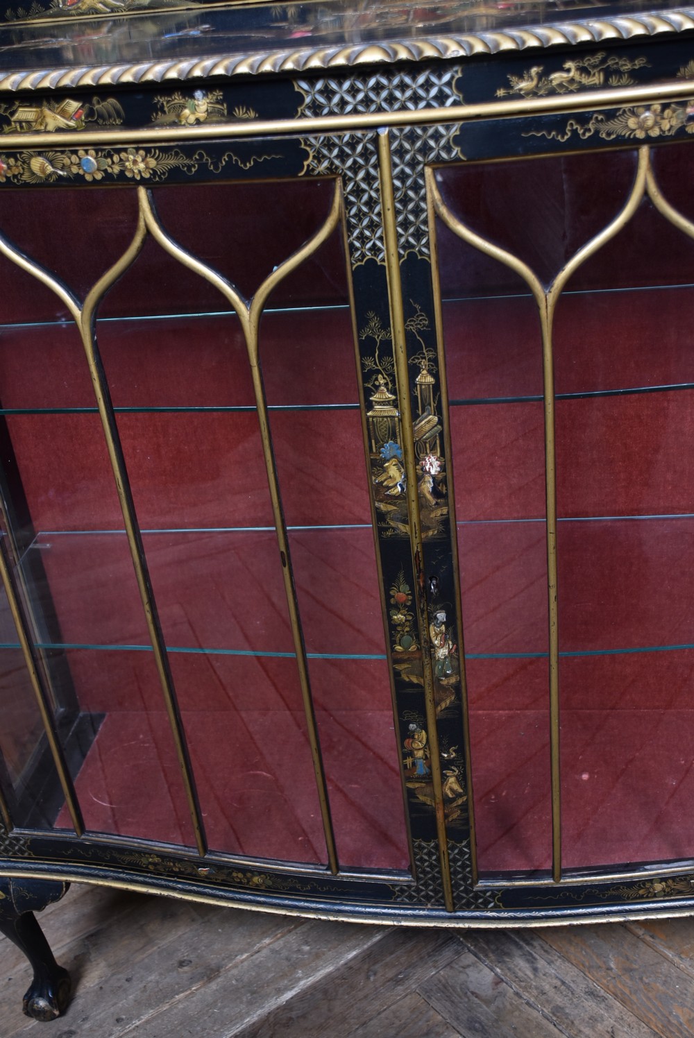 An Edwardian black lacquered display cabinet featuring hand-painted gold Chinoiserie motifs, arched astragal glazing, and cabriole legs. View VII
