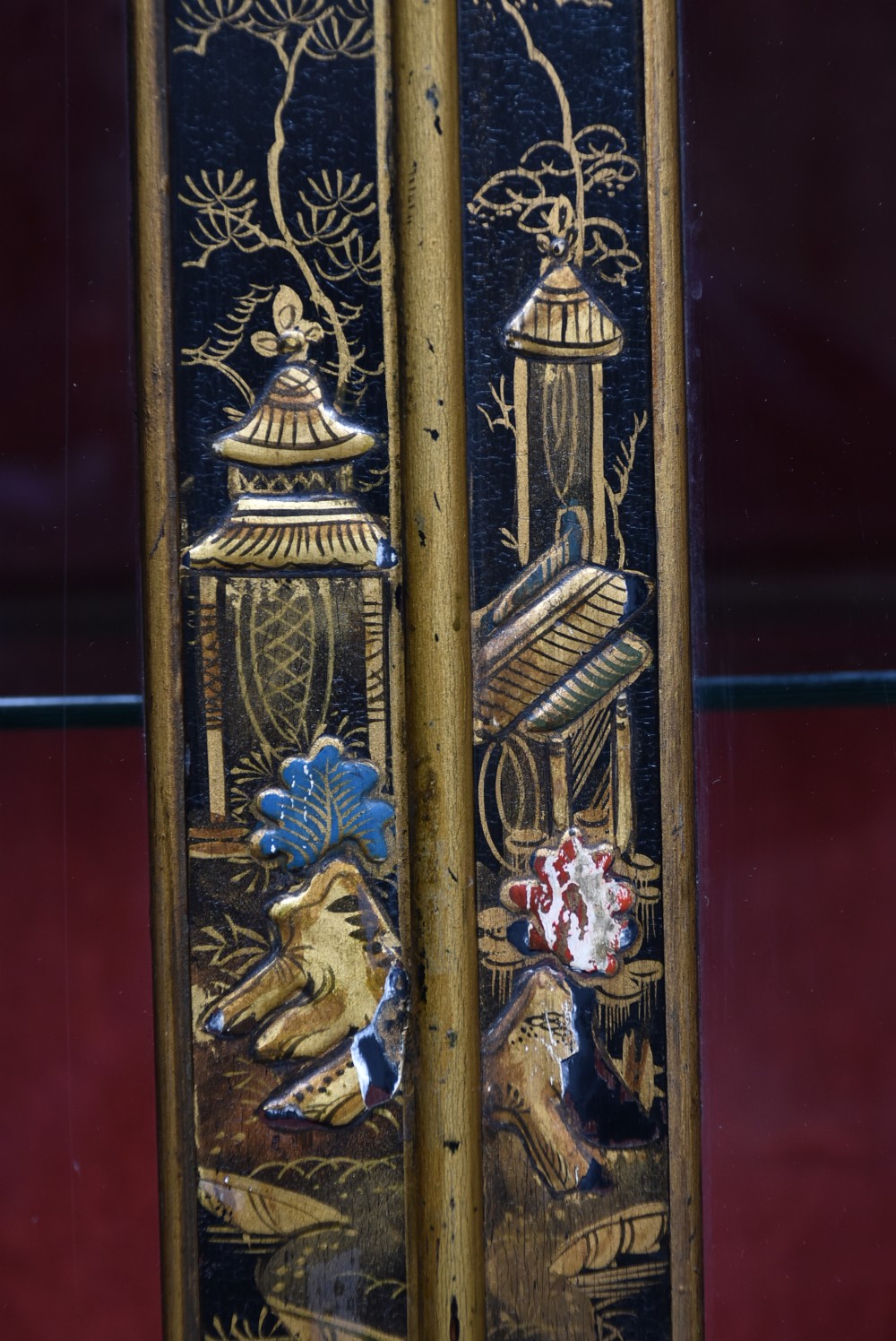 An Edwardian black lacquered display cabinet featuring hand-painted gold Chinoiserie motifs, arched astragal glazing, and cabriole legs. View X