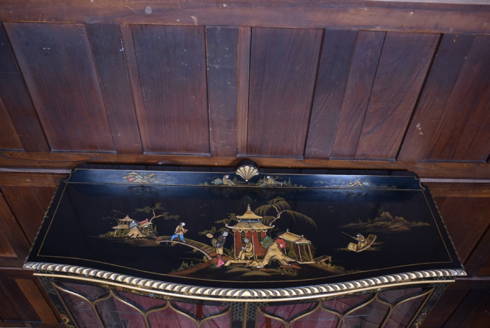An Edwardian black lacquered display cabinet featuring hand-painted gold Chinoiserie motifs, arched astragal glazing, and cabriole legs. View XII