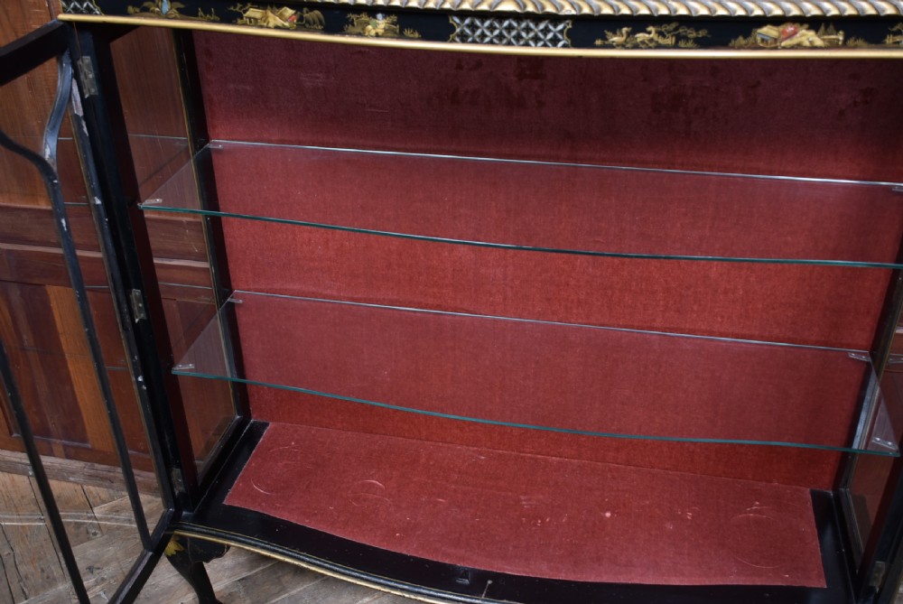 An Edwardian black lacquered display cabinet featuring hand-painted gold Chinoiserie motifs, arched astragal glazing, and cabriole legs. View XIX