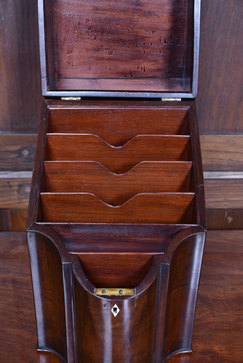 An antique Georgian mahogany sloping knife box with a serpentine front, silver-toned ring pull, and diamond-shaped keyhole escutcheon. View IX