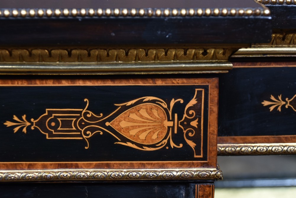 A Victorian ebonised and amboyna breakfront credenza featuring a central cupboard with a blue jasperware plaque flanked by open shelves and gilt fluted columns. View VIII