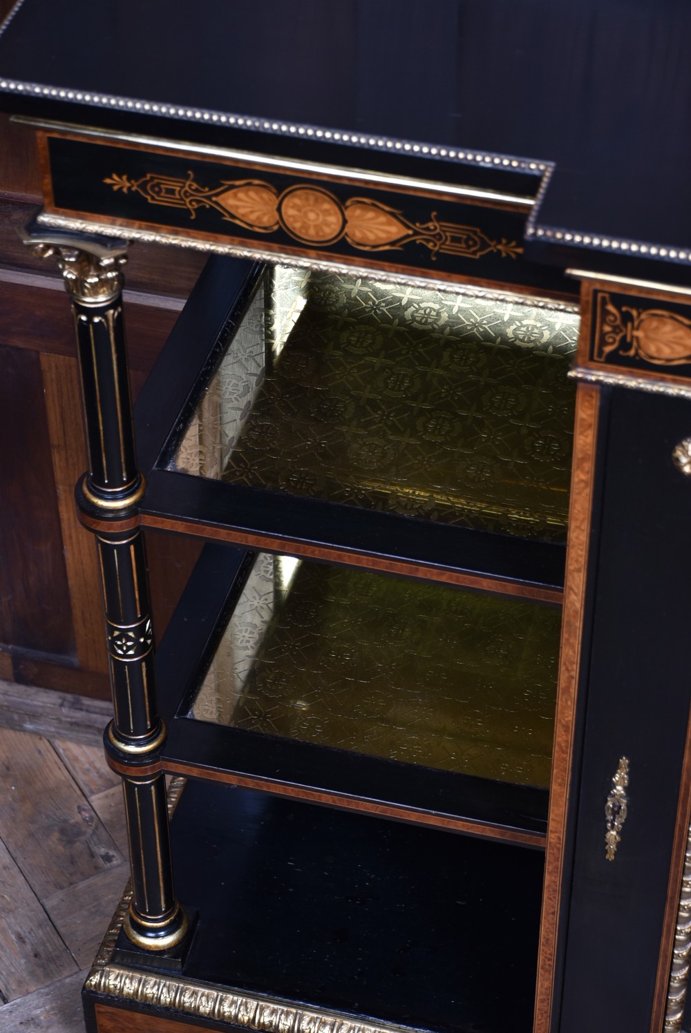 A Victorian ebonised and amboyna breakfront credenza featuring a central cupboard with a blue jasperware plaque flanked by open shelves and gilt fluted columns. View XIV