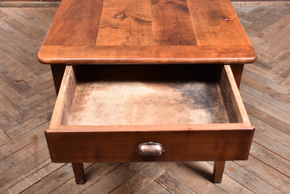 A long antique French cherry wood farmhouse table featuring tapered legs, a single side drawer with a metal cup handle, and a plank top with framed borders. View XIV