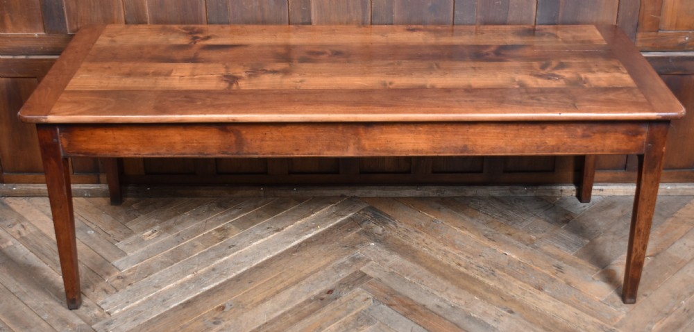 A long antique French cherry wood farmhouse table featuring tapered legs, a single side drawer with a metal cup handle, and a plank top with framed borders. View XVIII
