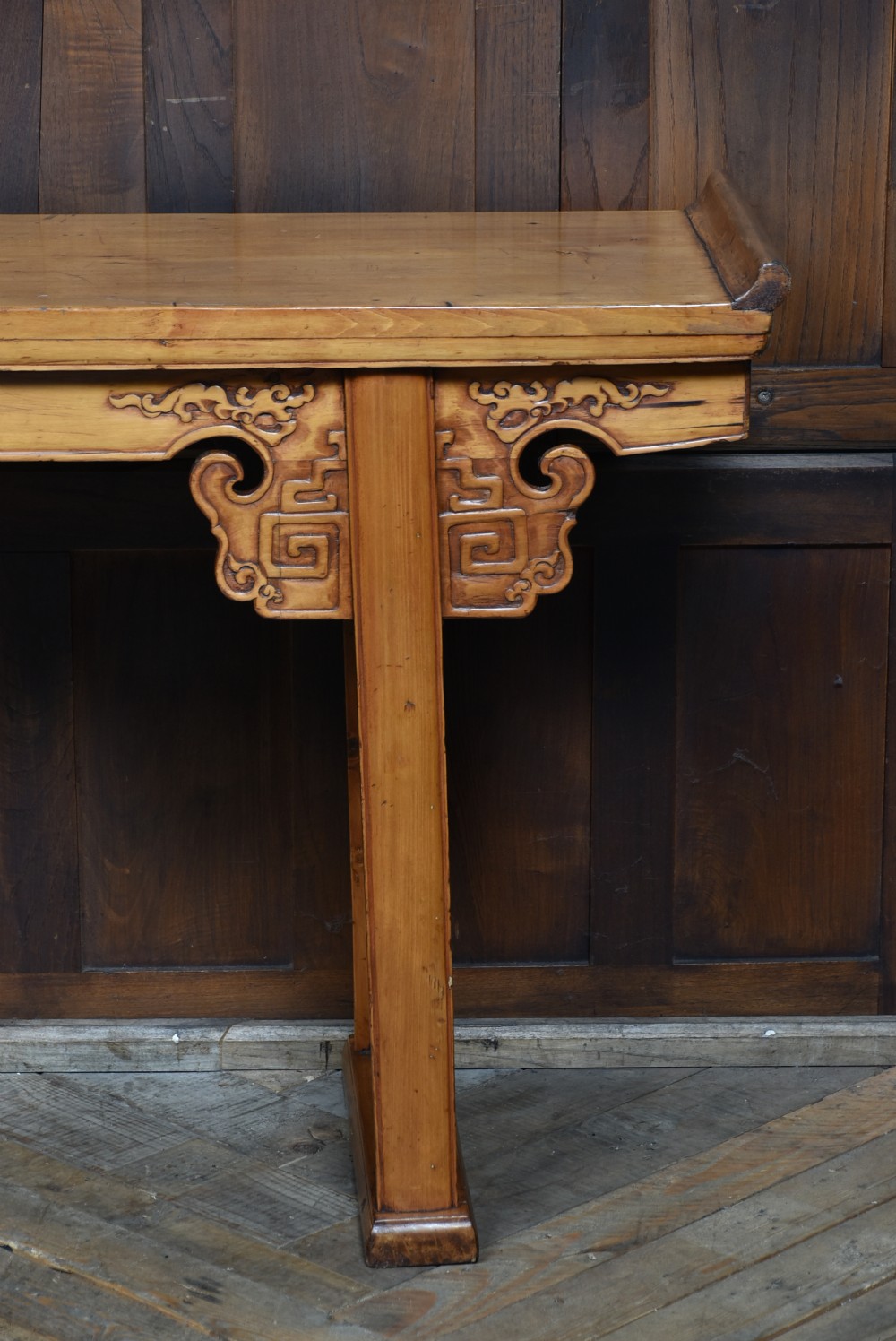 A long, light honey brown timber Chinese altar console table featuring upturned flange ends and carved decorative spandrels. View III