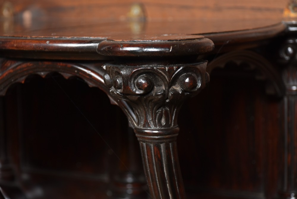 A Victorian dark rosewood carved wall bracket shelf featuring three fluted columns with carved capitals and scalloped arches. View VI