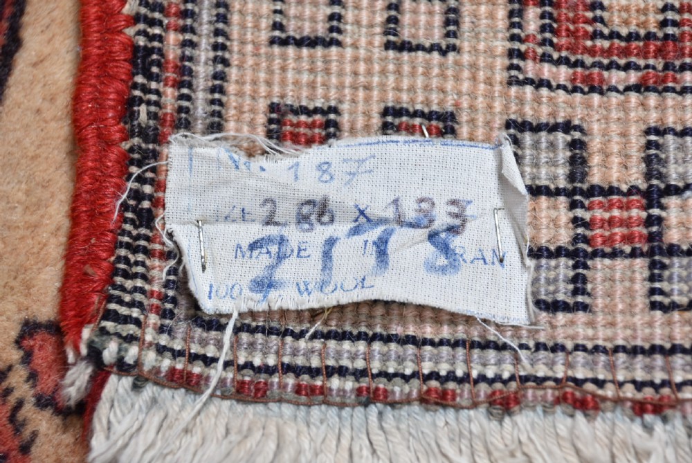 A hand-knotted wool runner rug featuring geometric medallions, bird motifs, and decorative borders in terracotta, cream, blue, and dark navy tones. View XI