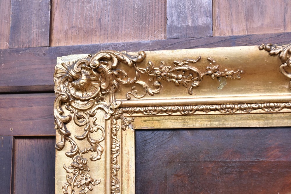 An antique 19th-century oil portrait painting on canvas depicting an elderly woman wearing a lace bonnet, set inside a heavy ornate giltwood frame. View VII