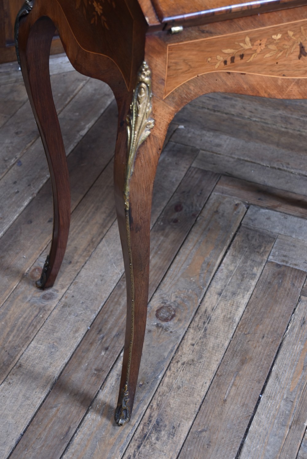 A Victorian marquetry bureau de dame desk featuring floral wood inlays, a slant front writing slope, pierced brass top gallery, and cabriole legs with brass mounts. View VIII