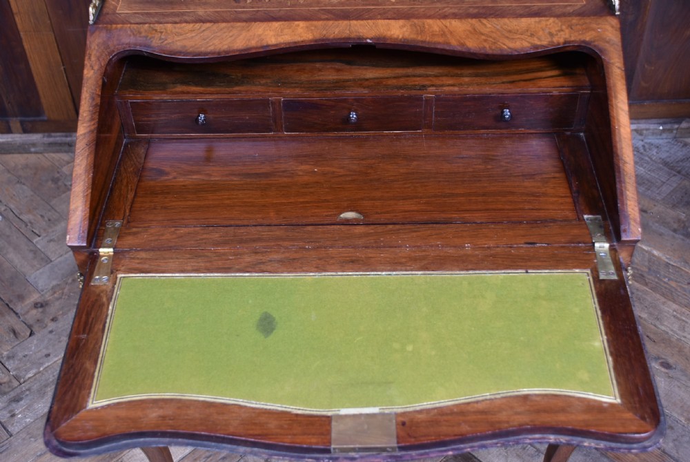 A Victorian marquetry bureau de dame desk featuring floral wood inlays, a slant front writing slope, pierced brass top gallery, and cabriole legs with brass mounts. View XI
