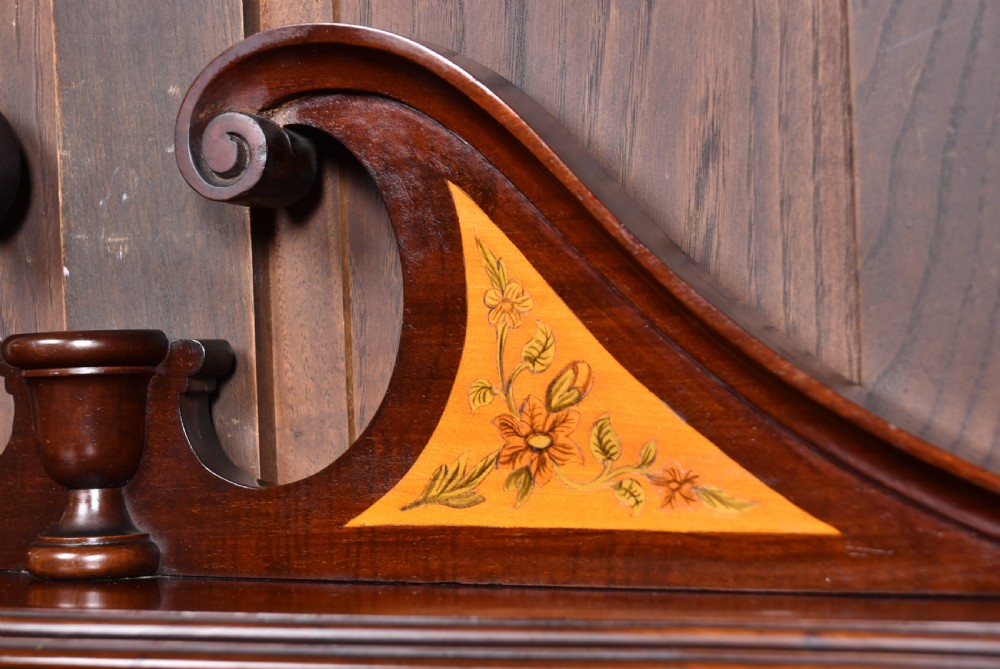 An Edwardian mahogany display cabinet featuring hand-painted floral borders, an oval mirror top section, glazed doors, and cabriole legs. View IX