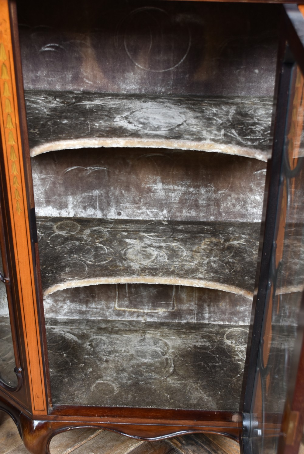 An Edwardian mahogany display cabinet featuring hand-painted floral borders, an oval mirror top section, glazed doors, and cabriole legs. View XII