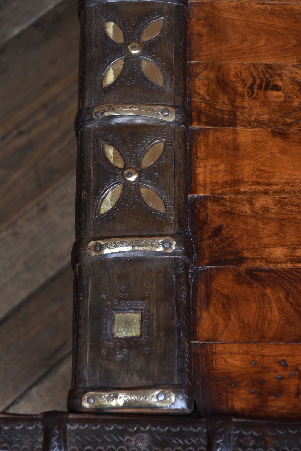 A low square coffee table crafted from a dark reclaimed bullock cart frame with decorative brass studding and stout carved legs. View IX