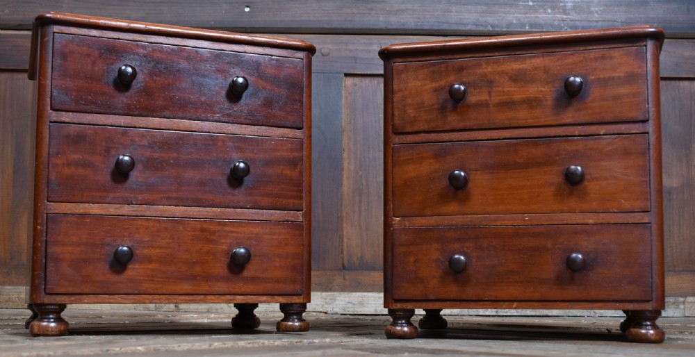 A pair of miniature mahogany chests of drawers, each featuring three drawers with turned wooden knobs and small turned feet. View II