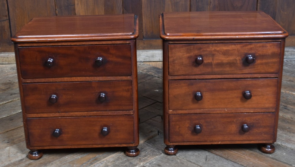 A pair of miniature mahogany chests of drawers, each featuring three drawers with turned wooden knobs and small turned feet. View IV