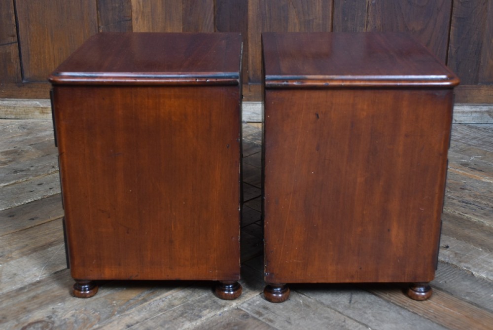 A pair of miniature mahogany chests of drawers, each featuring three drawers with turned wooden knobs and small turned feet. View VII