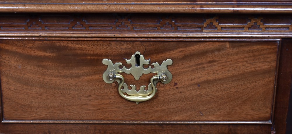 A Georgian style dark mahogany lowboy featuring five drawers with brass handles, a carved apron, and cabriole legs with ball and claw feet. View II