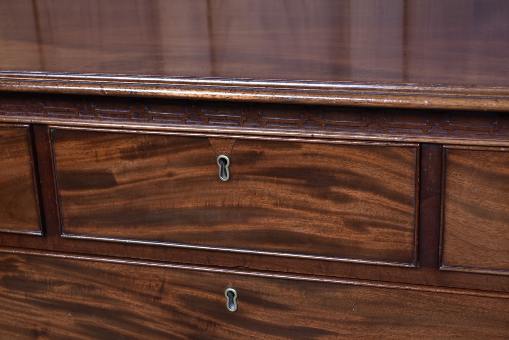A Georgian style dark mahogany lowboy featuring five drawers with brass handles, a carved apron, and cabriole legs with ball and claw feet. View VI
