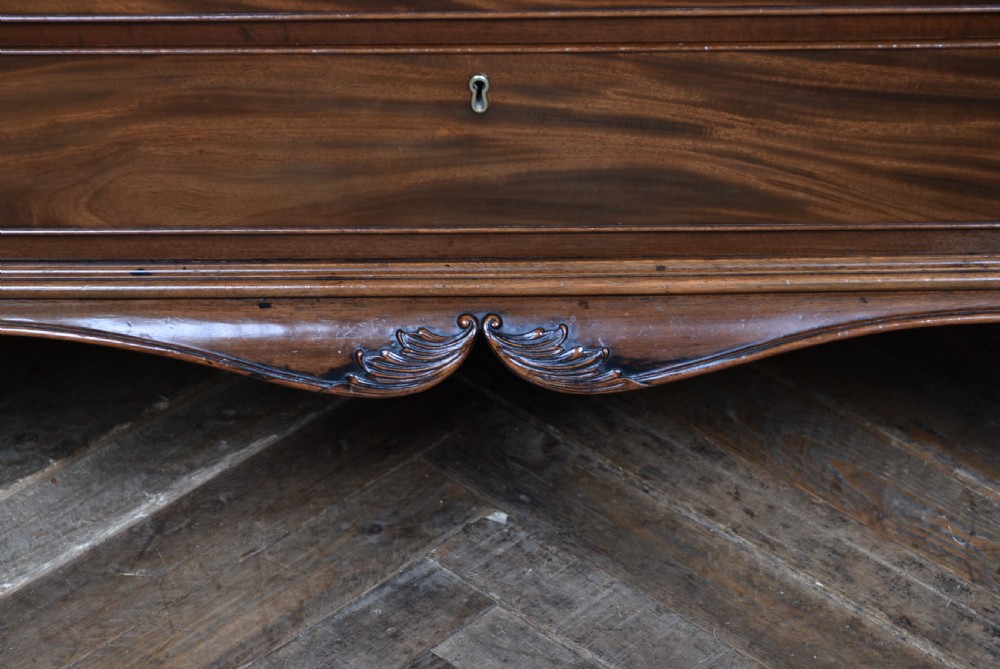 A Georgian style dark mahogany lowboy featuring five drawers with brass handles, a carved apron, and cabriole legs with ball and claw feet. View VII
