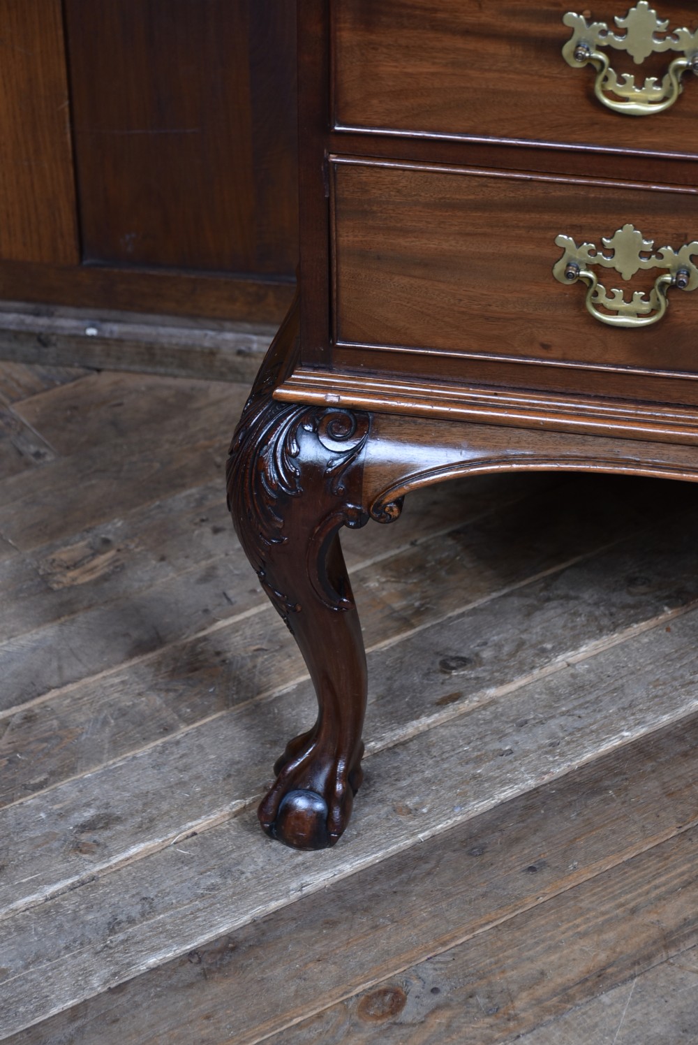A Georgian style dark mahogany lowboy featuring five drawers with brass handles, a carved apron, and cabriole legs with ball and claw feet. View VIII