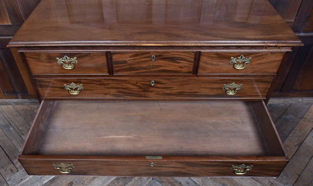 A Georgian style dark mahogany lowboy featuring five drawers with brass handles, a carved apron, and cabriole legs with ball and claw feet. View XII