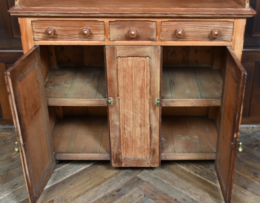 A Scottish Victorian pine kitchen dresser featuring a raised gallery with four small drawers, three upper frieze drawers, and a lower three-door cupboard with diagonal timber panelling. View XI