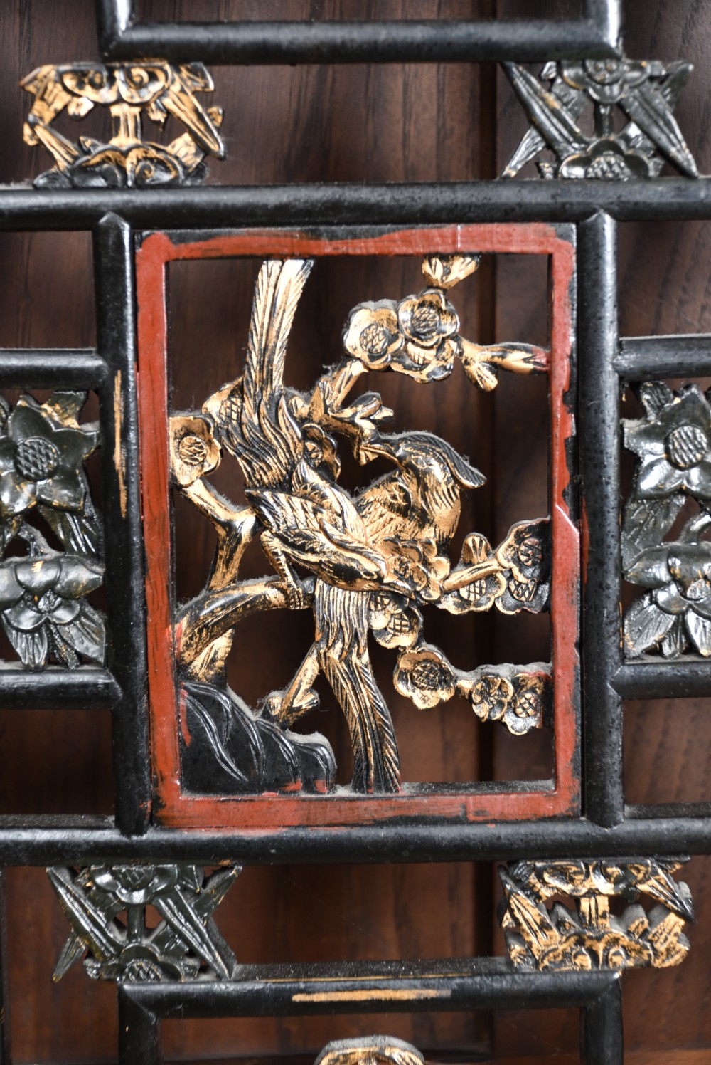 A four-panel tall folding room screen featuring red-lacquered timber framing, intricate black lattice fretwork, and carved gilded lower panels. View XIX