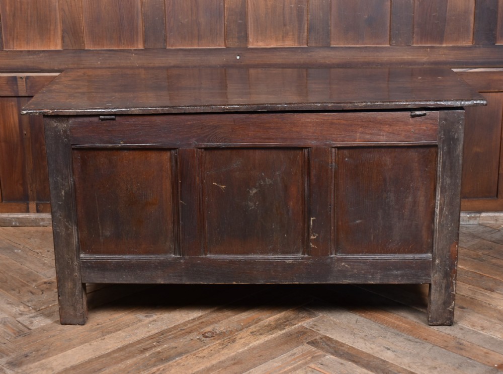 An 18th-century dark oak coffer with a rectangular top lid, three front recessed panels, and a central iron keyhole escutcheon. View XII