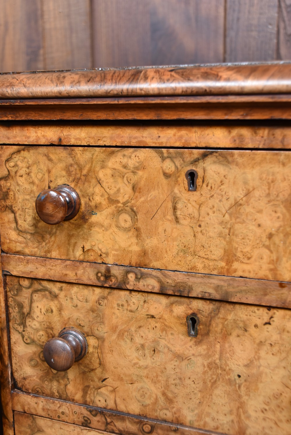 A pair of antique Victorian burr walnut bedside drawers, each fitted with five drawers, turned wooden knobs, and a plinth base. View VII