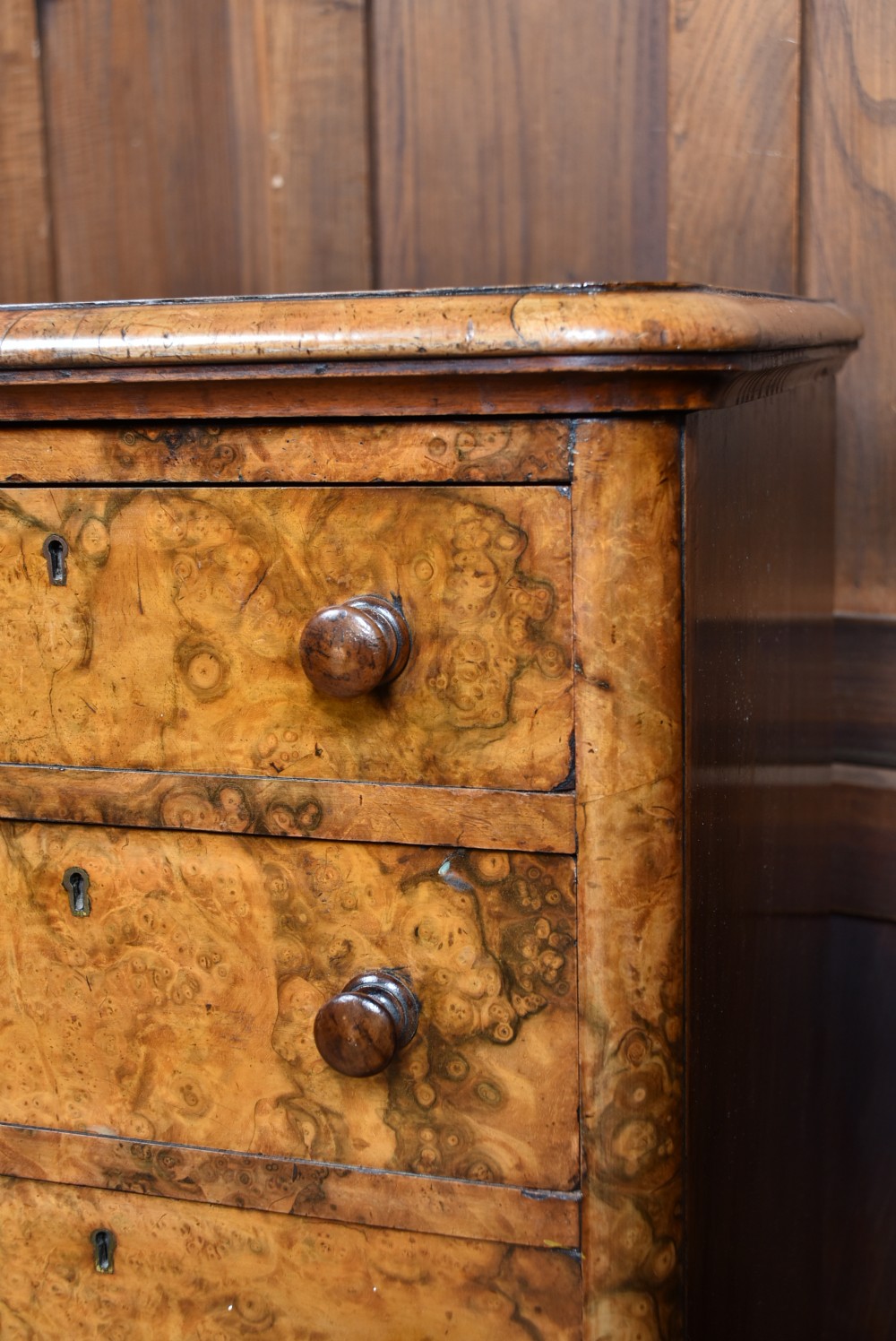 A pair of antique Victorian burr walnut bedside drawers, each fitted with five drawers, turned wooden knobs, and a plinth base. View VIII