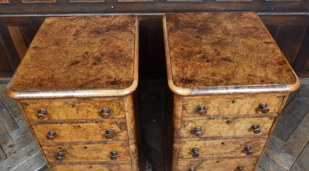 A pair of antique Victorian burr walnut bedside drawers, each fitted with five drawers, turned wooden knobs, and a plinth base. View XII