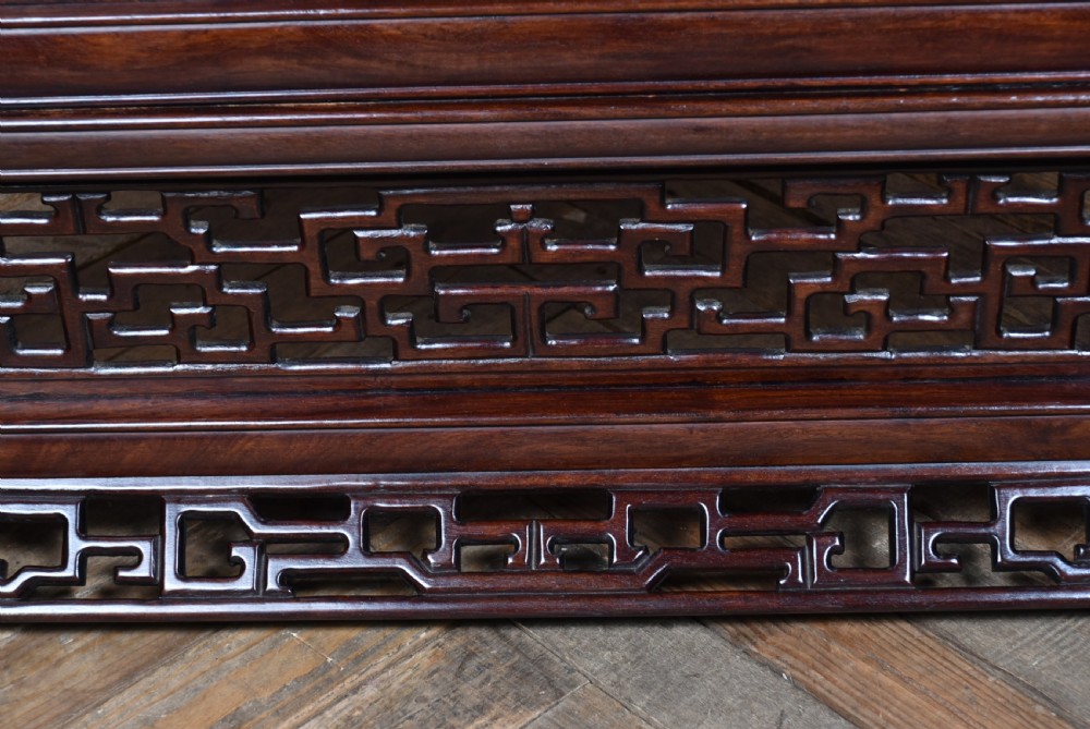 A dark brown carved Chinese hardwood table screen featuring relief-carved phoenix and floral motifs on a central panel set into a stand with openwork fretwork. View VI