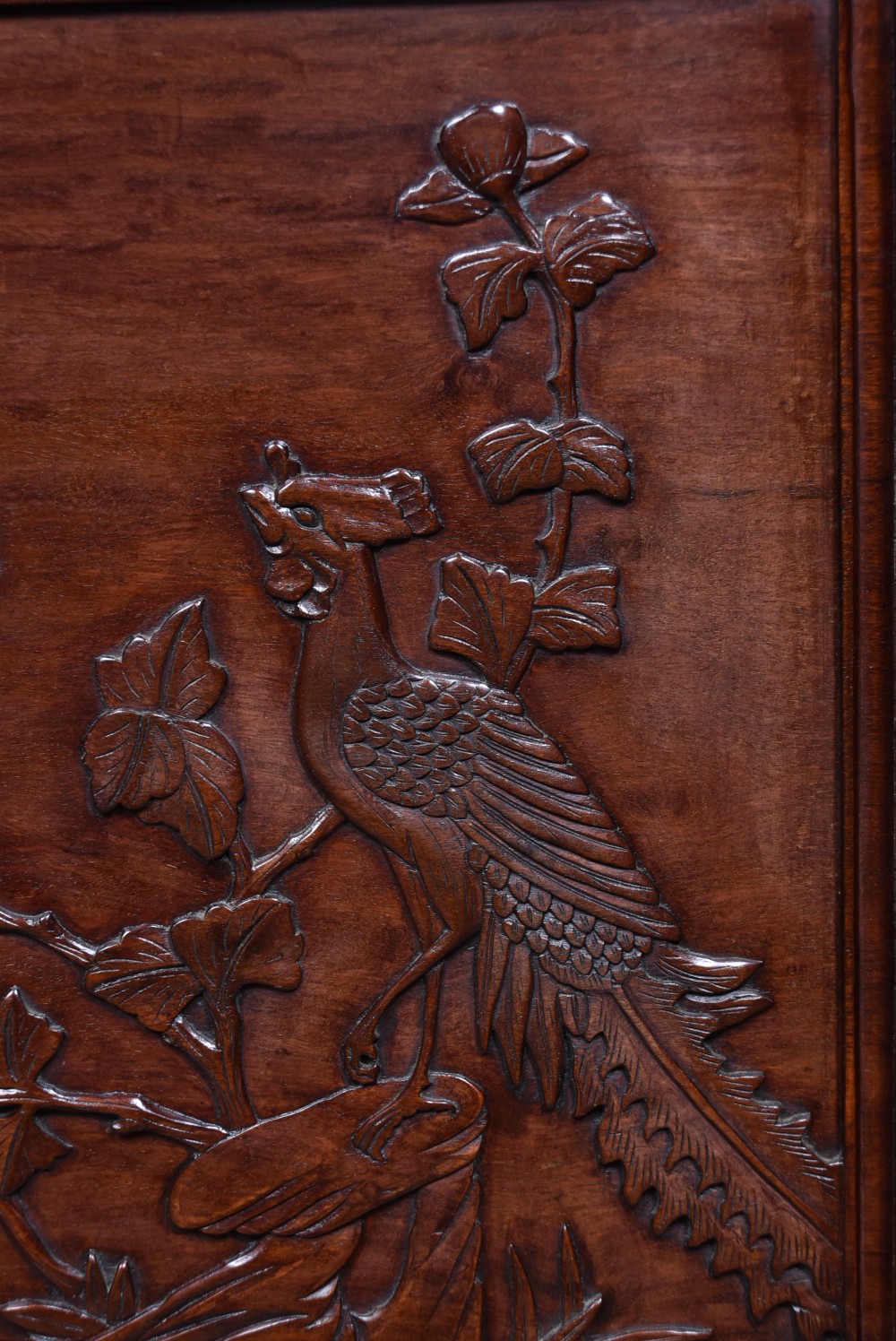 A dark brown carved Chinese hardwood table screen featuring relief-carved phoenix and floral motifs on a central panel set into a stand with openwork fretwork. View VII