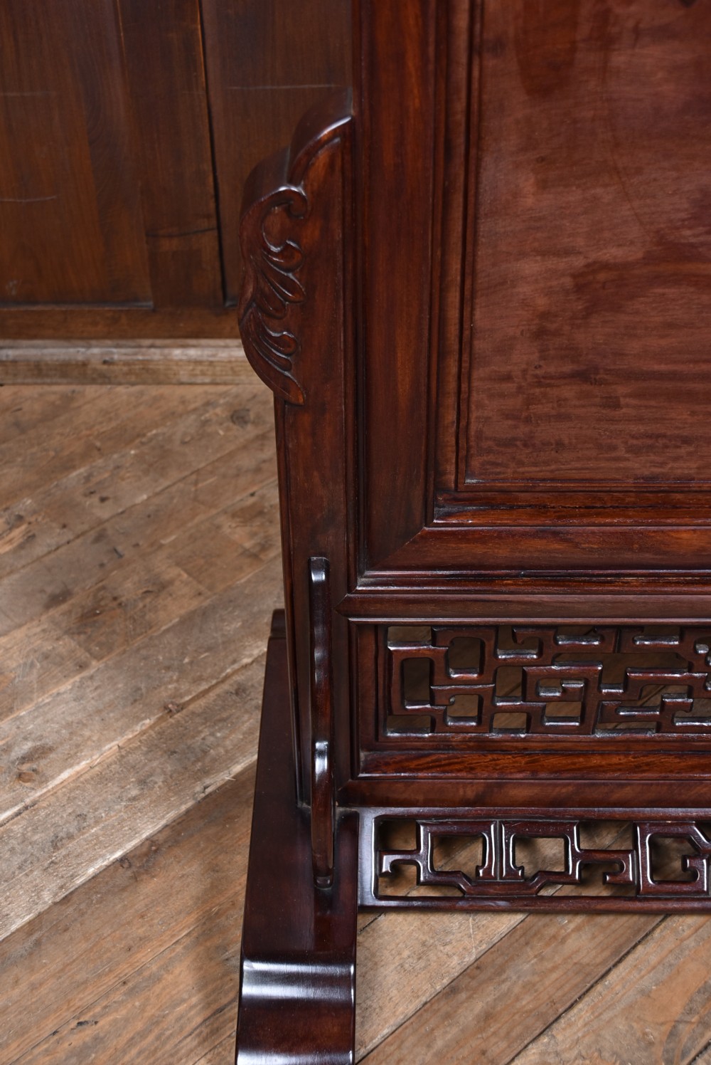 A dark brown carved Chinese hardwood table screen featuring relief-carved phoenix and floral motifs on a central panel set into a stand with openwork fretwork. View IX