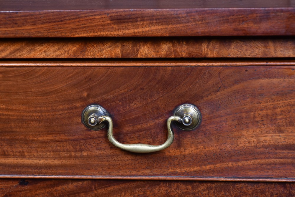 A tall Georgian mahogany secretaire chest featuring six graduated drawers, brass swan-neck handles, and ogee bracket feet. View V