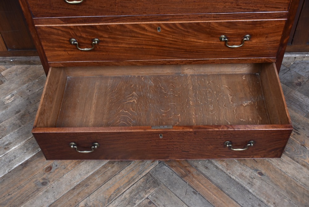 A tall Georgian mahogany secretaire chest featuring six graduated drawers, brass swan-neck handles, and ogee bracket feet. View VII