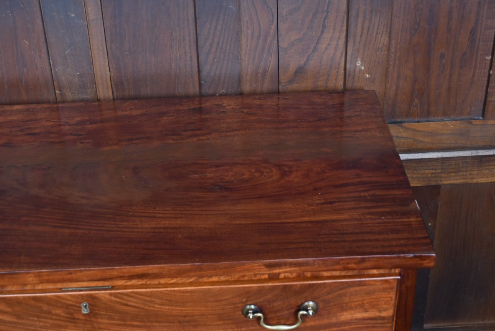 A tall Georgian mahogany secretaire chest featuring six graduated drawers, brass swan-neck handles, and ogee bracket feet. View XIV