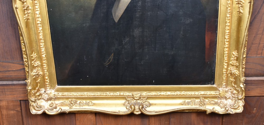A nineteenth-century oil painting depicting a gentleman in dark formal wear within a carved gilded frame. View X